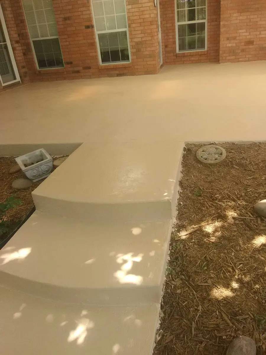 Actual completed cream decorative patio overlay outside a brick home